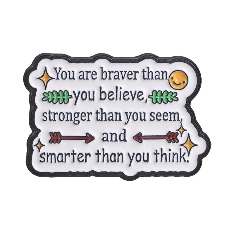A black enamel pin featuring the quote You are braver than you believe stronger than you seem and smarter than you think.