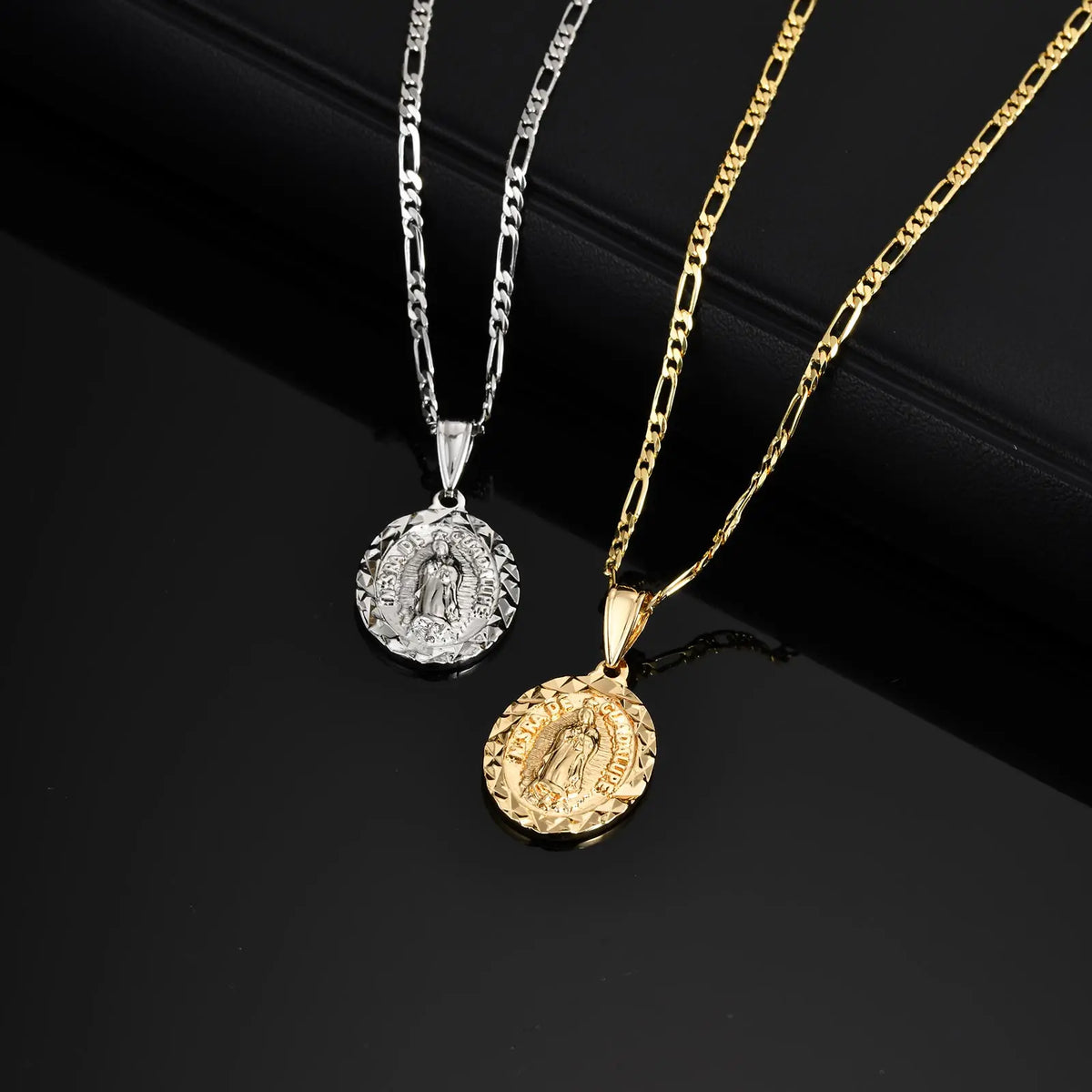 A pair of gold and silver pendant necklaces featuring religious figures, including a detailed Virgin Mary prayer pendant.