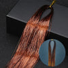 A bundle of reddish-brown hair extensions with glitter strands is displayed against a dark background.