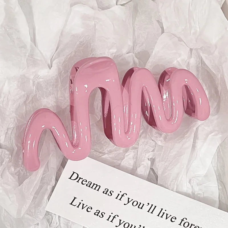 Pinzas para el cabello tipo ola de gel rosa sobre papel de hisopo arrugado