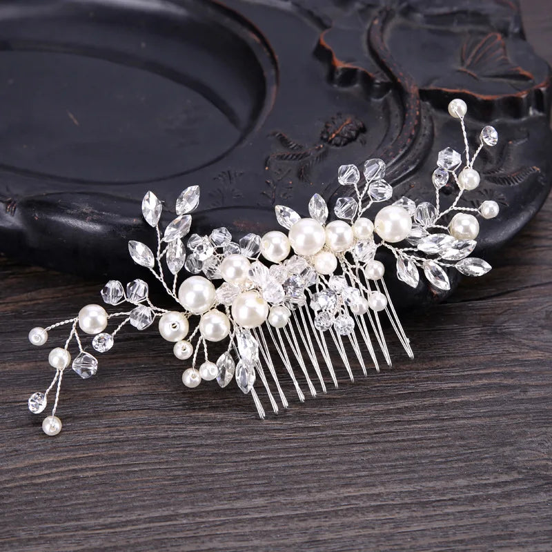 Une délicate peigne pour cheveux de mariée en cristal avec des accents de perles et de strass clairs.