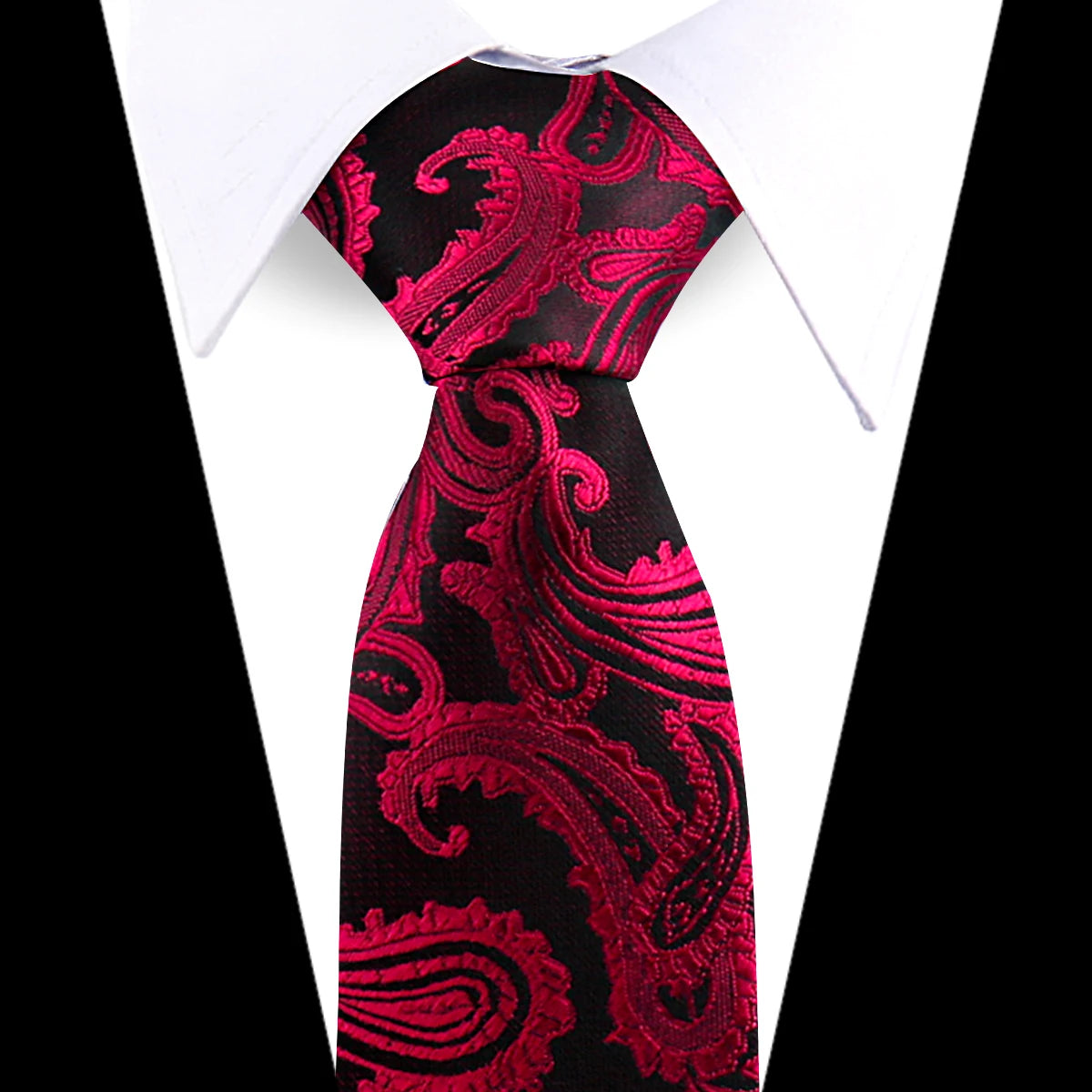 A close-up of an elegant men's floral paisley silk necktie in black and deep red on a white shirt.