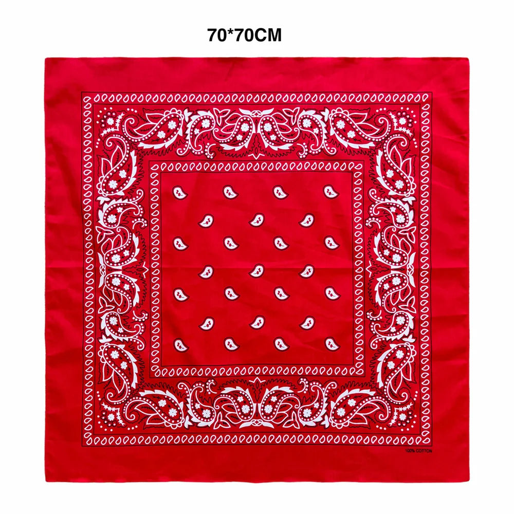 A red square scarf with white paisley embroidery and a decorative border.