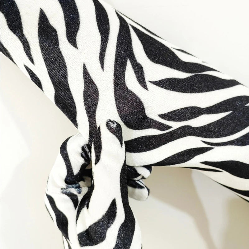 Nahaufnahme langer Performance-Handschuhe mit schwarz-weißem Zebraprint