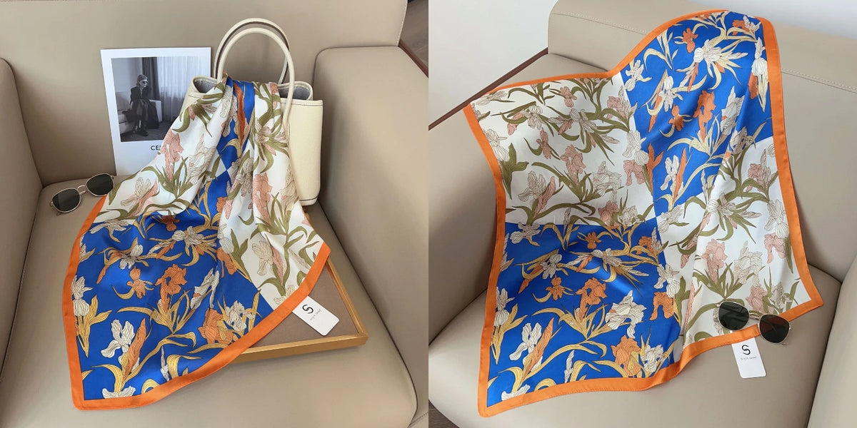 A blue and white floral print silk scarf draped on a wooden tray in a light beige interior setting.