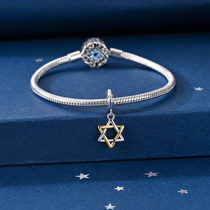 Sterling silver star moon charm bracelet with a blue gemstone pendant displayed on a dark blue velvet box.