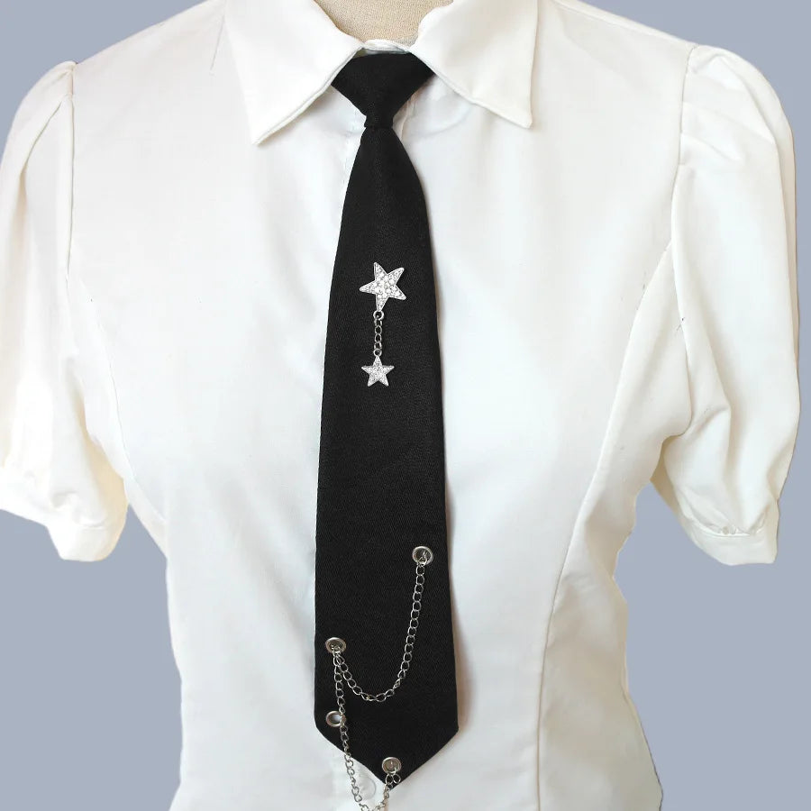 Black tie with a silver star pendant and chain worn under a white collared shirt.