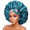 A woman wearing a teal satin sleep bonnet with an elastic band