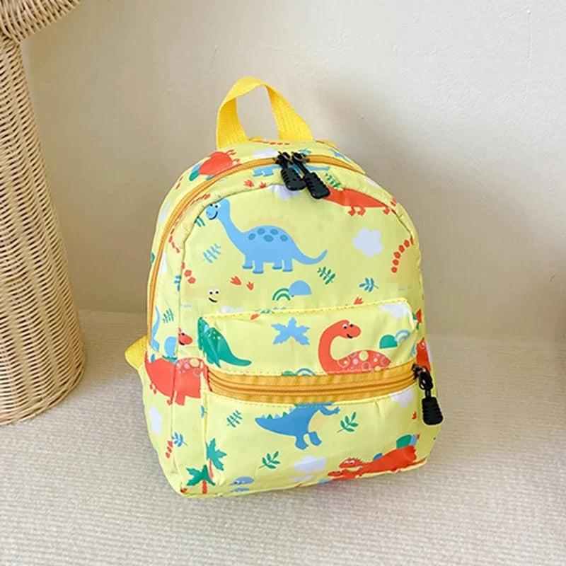A yellow kids backpack featuring a cute dinosaur and unicorn pattern.