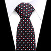 A black necktie with a white and red polka dot pattern worn under a white dress shirt.