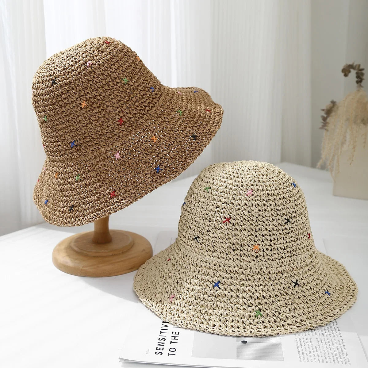 Sombrero de paja panama tejido a mano color beige, exhibido en un soporte de madera.