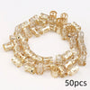 A set of 50 small, gold-colored metal hair rings and clips.