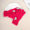 A pair of bright pink knit gloves with gray accents resting on a white plate.
