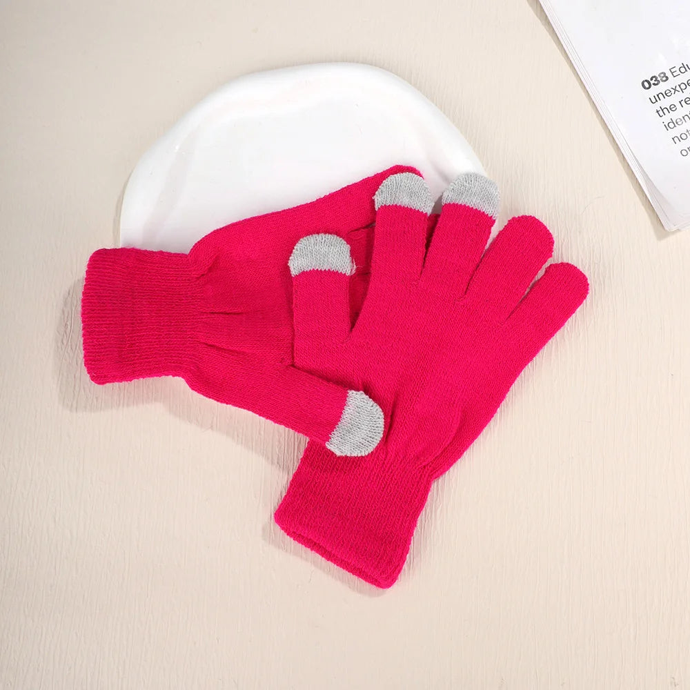A pair of bright pink knit gloves with gray accents resting on a white plate.