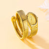 A close-up shot of a gold-toned ladies watch with a snake design on the strap, resting on a light background.