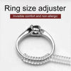 A silver ring size adjuster tool with a clear plastic ring being measured.