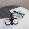 A light blue leather pouch with a black strap and two round, decorative patches is displayed on a white surface.