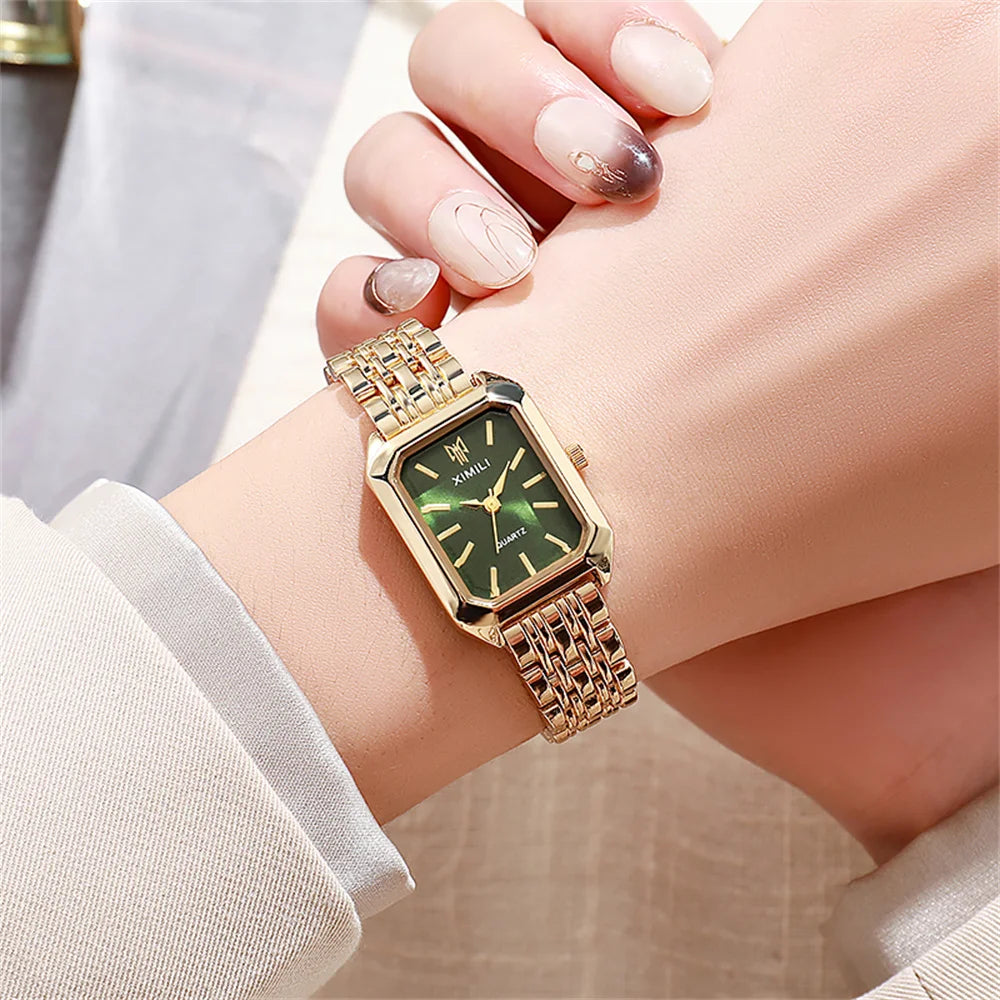 A close-up of an elegant gold plated quartz fashion watch worn on a wrist with manicured nails.