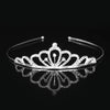 Tiara y corona de princesa de cristal brillante en el cabello reflejada en una superficie oscura.