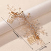 A delicate gold leafed crystal hair comb with pearl accents shown against a light background.