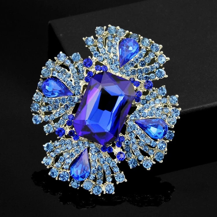 Broche de pierre bleue brillante avec un diamant violet central entouré de cristaux bleus scintillants.