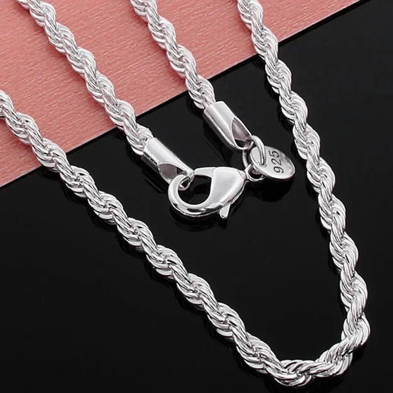 Silver rope charm necklace with a heart pendant displayed on a black background