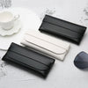 Black and white elegant leather eyeglass cases displayed on a white surface.