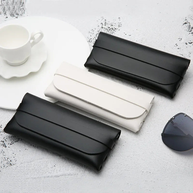 Black and white elegant leather eyeglass cases displayed on a white surface.