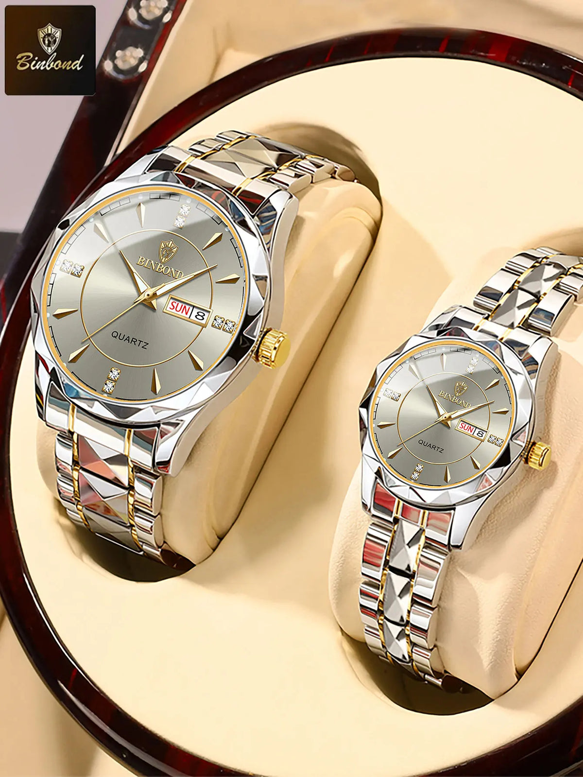 A pair of silver stainless steel quartz watches are displayed on a light-colored surface.