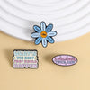 A blue enamel lapel pin shaped like a flower with the text I AM Loved and strong on the petals