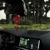 A wooden cross pendant is displayed on a car dashboard screen.