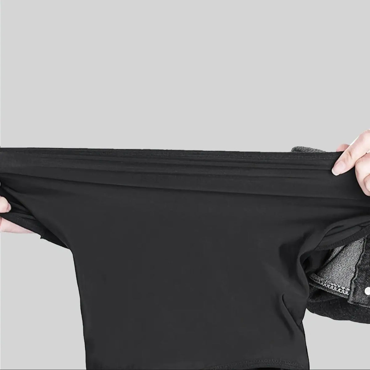 Black windproof dustproof ski mask and neck cover being held by a hand