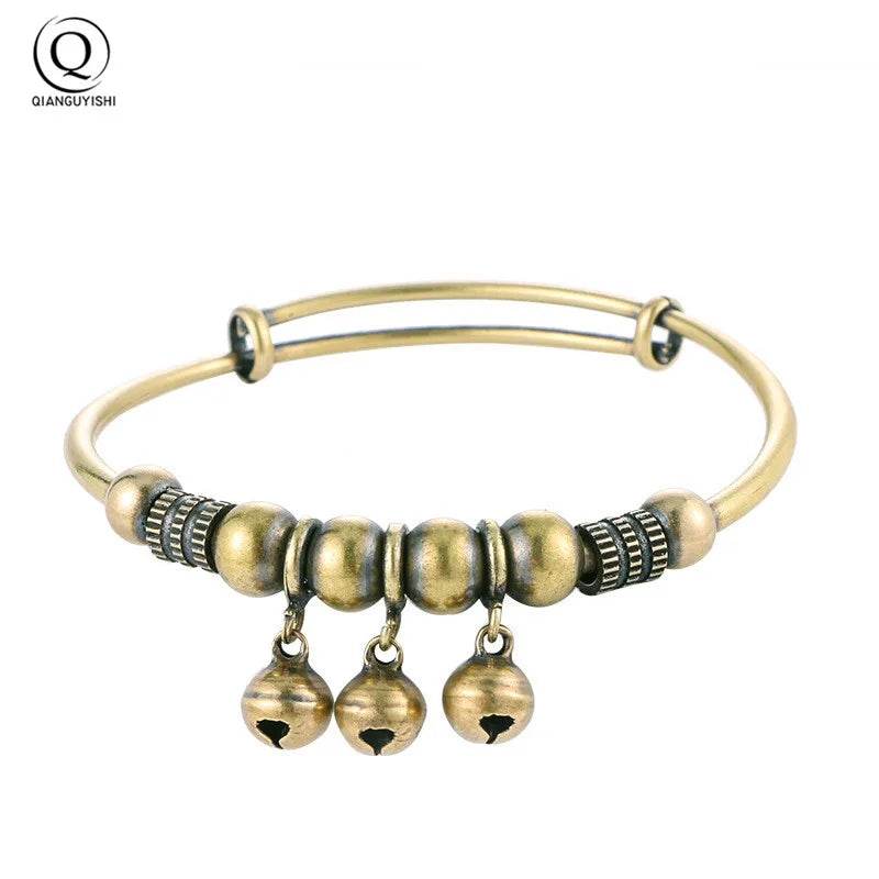 Vintage brass bell charm bracelet with a gold-toned bangle and dangling bell charms