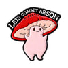 An enamel pin featuring a pink, blob-like character with a red, stylized mouth and a black banner that reads Lets Commit Arso