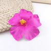 A vibrant magenta hibiscus flower resting on a woven natural fiber background.