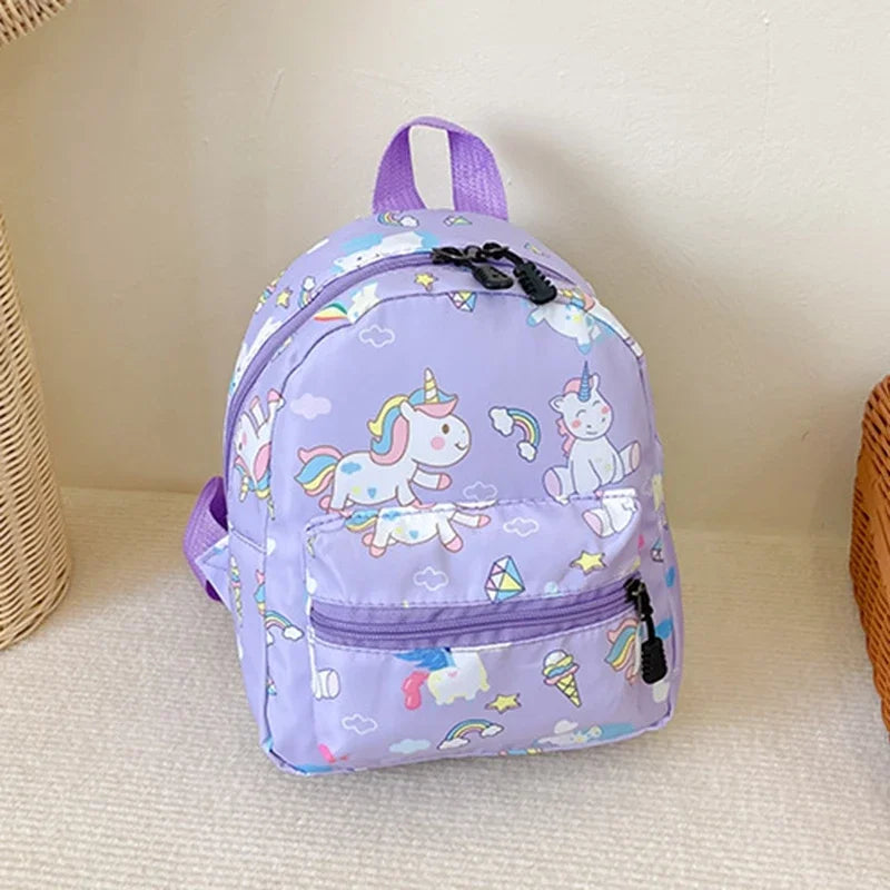 A purple kids backpack featuring a cute dinosaur and unicorn pattern with pastel clouds and rainbows.