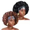 A model wears a black satin sleep bonnet with an elastic band and gold accent, shown in profile.