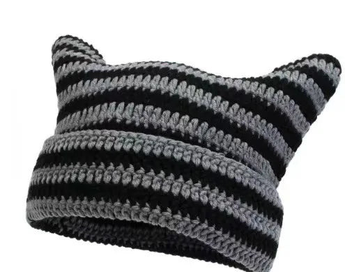 A close-up of a black and gray crocheted cat ears beanie hat.