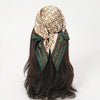 A brown hair styled with a silk scarf and headband set featuring gold chain print fabric