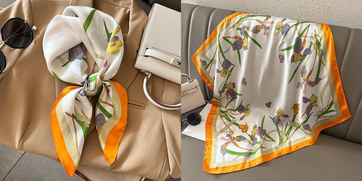 A floral print silk scarf in white and orange tones draped over a beige blazer.