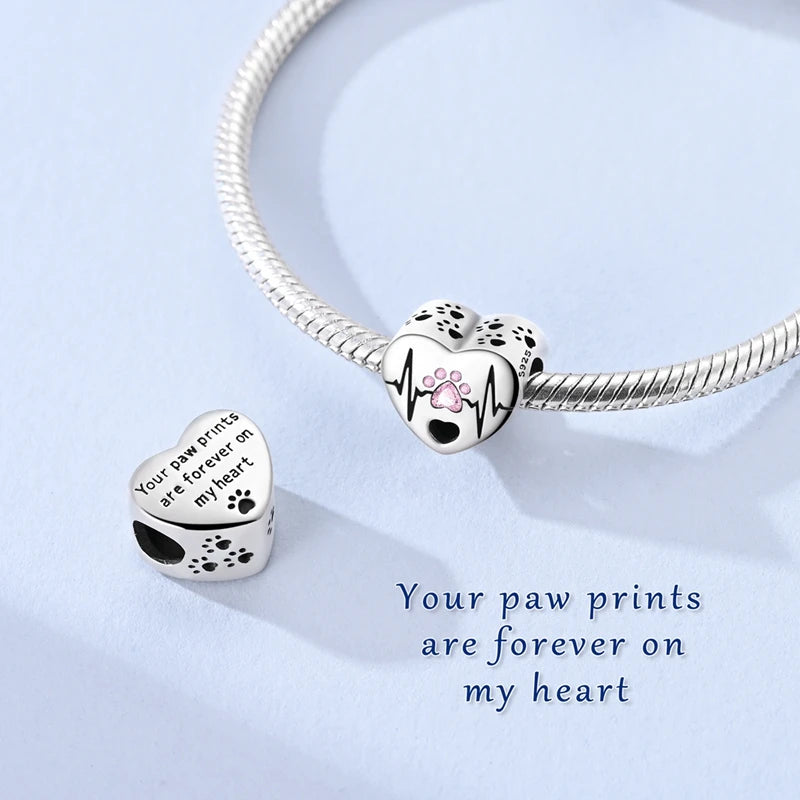 Sterling silver charm bracelet featuring paw print heart charms engraved with the message Your paw prints are forever on my h