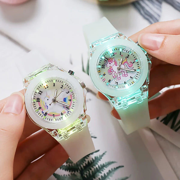 A hand holds a light green unicorn fashion watch for girls and women on a white background.