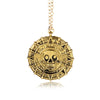 Gold skull pendant necklace with a chain hanging from it.
