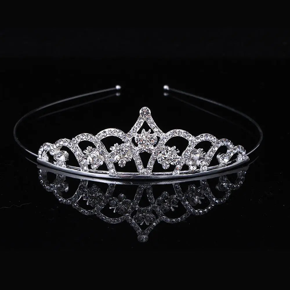 A sparkling crystal hair crown for women displayed on a reflective surface.