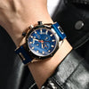 A close-up of a men's luxury quartz sport watch with a gold-toned case and blue dial on a wrist.