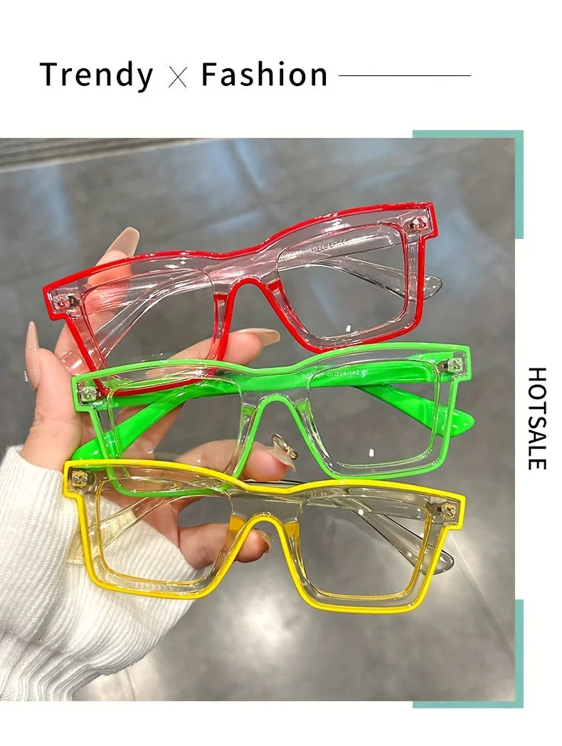 A hand holds a stack of colorful square frame costume glasses in red, green, and yellow.