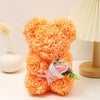 Un bouquet de ours en peluche rose en mousse orange à côté d'une lampe de couleur crème.