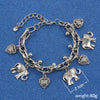 Silver chain bracelet with elephant charms and a heart pendant on a blue background