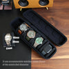 A black leather watch travel case organizer holding several wristwatches and a smartphone.