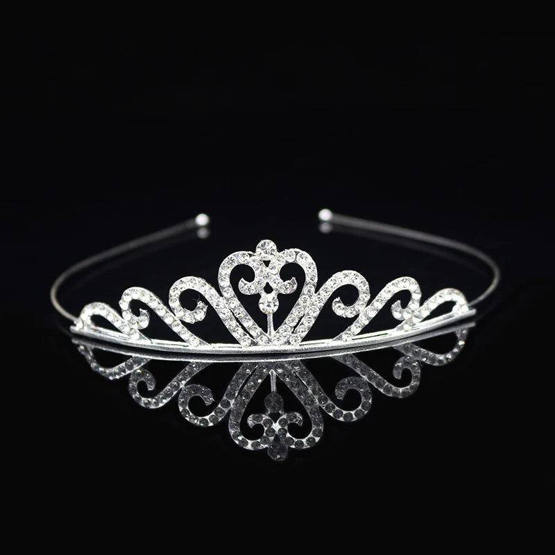 Tiara de cristal brillante para el cabello sobre una superficie negra reflectante.